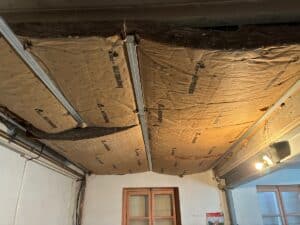 Plafonnier en cours de rénovation avec isolation Knauf Insulation ECOSE sous cadres métalliques, laissant apparaître le matériau isolant.