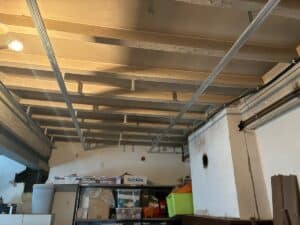 Plafond exposé avec solives apparentes et structure métallique pour faux-plafond, éclairage bas, rangement divers avec boîtes TRISTAR et AQUATEC.